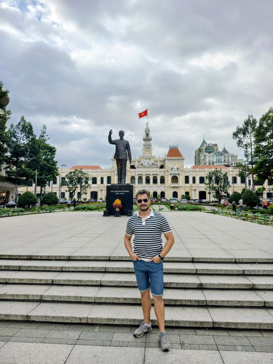 Z kolonialnym tłem przed pomnikiem Ho Chi Minha